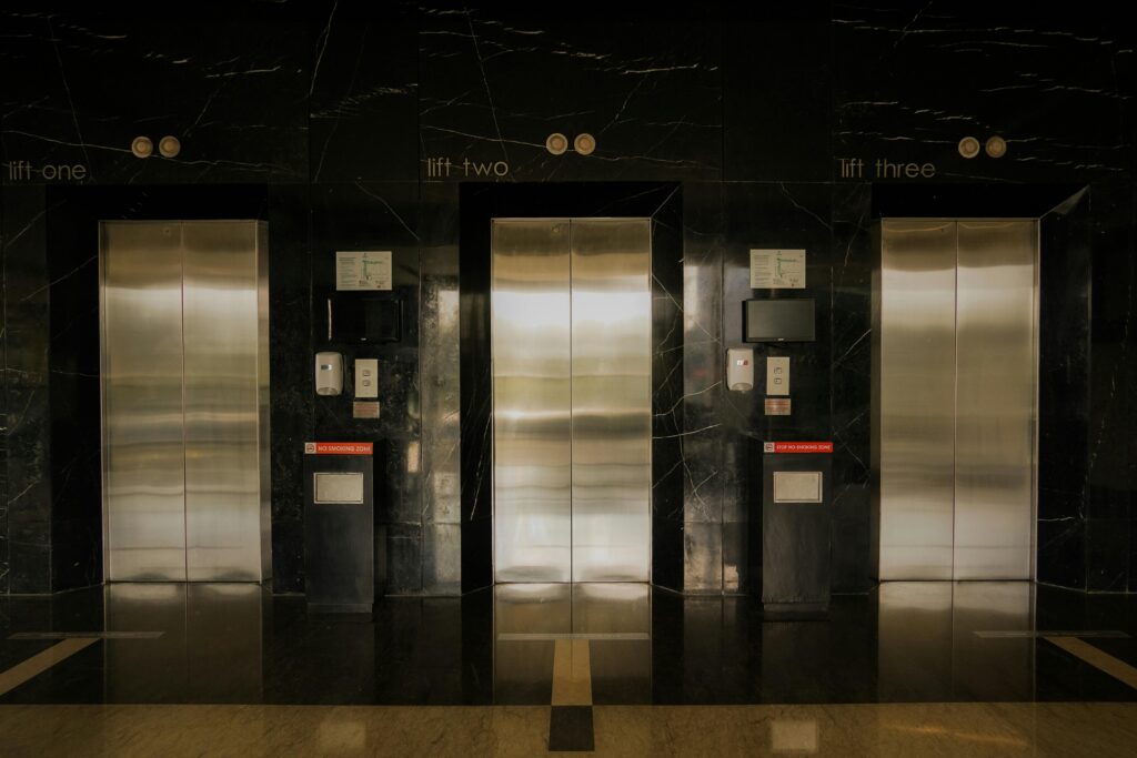 Sleek elevator lobby with stainless steel doors, reflecting modern architecture.