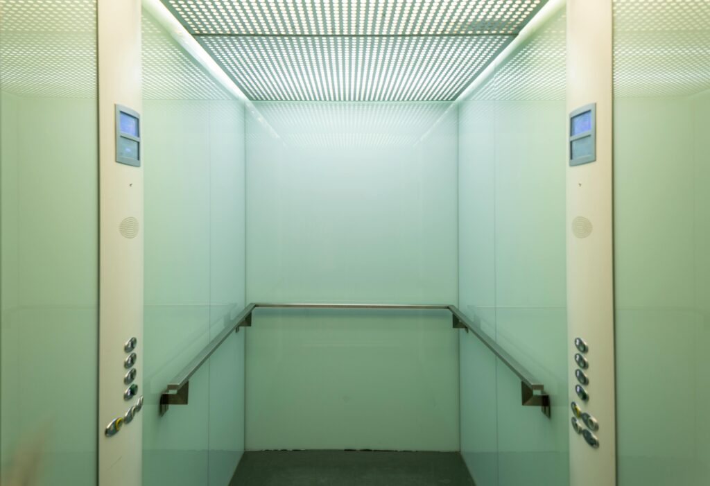 Empty elevator cabin showcasing a clean and minimalist interior with soft lighting.